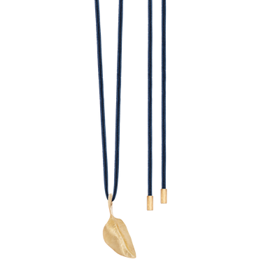 Blaues Seidenhalsband von Ole Lynggaard in Fischgräten- Flechtung und Goldkappen als Enden. Trage Beispiel mit kleinem Anhänger Blatt aus Gold
